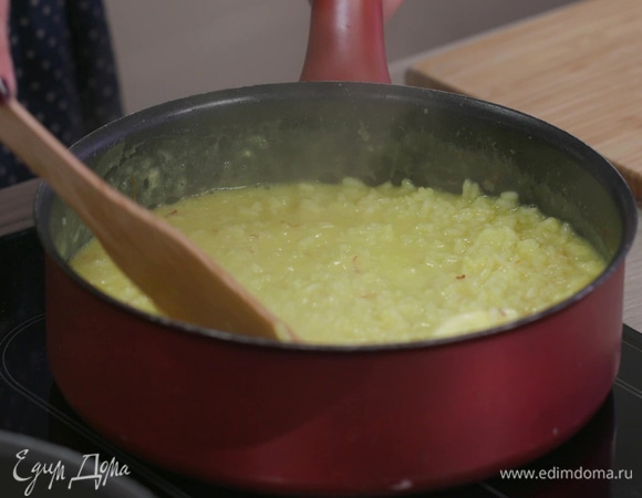 В практически готовое ризотто влить молоко с шафраном, оставшийся мартини, все перемешать и готовить еще 1–2 минуты, затем добавить 1 ст. ложку сливочного масла, еще раз все перемешать и выключить огонь.