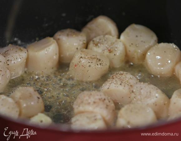 В отдельной сковороде разогреть оставшееся сливочное масло и обжарить чеснок, затем добавить гребешки, посолить, поперчить, влить коньяк и обжаривать все 2–3 минуты под крышкой и минуту без крышки.