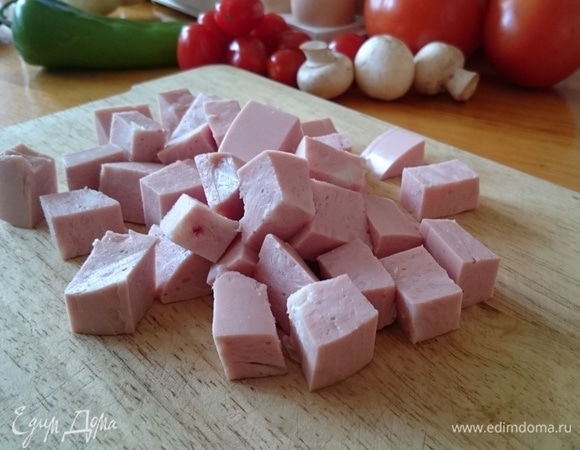Нарежьте кубиками колбасу.