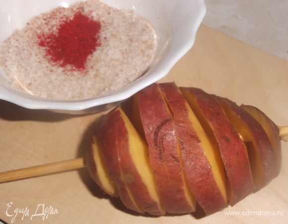 Картофель хорошо вымыть. Надеть на шпажку. Ножом сделать надрезы по спирали по всей длине картошки. Слегка раздвинуть руками. Смешать специи: соль, паприку и панировочные сухари.