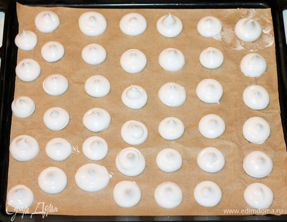 Выкладываем безе в кулинарный мешок с насадкой. Застилаем противень бумагой для выпечки и при помощи корнетика отсаживаем безе.