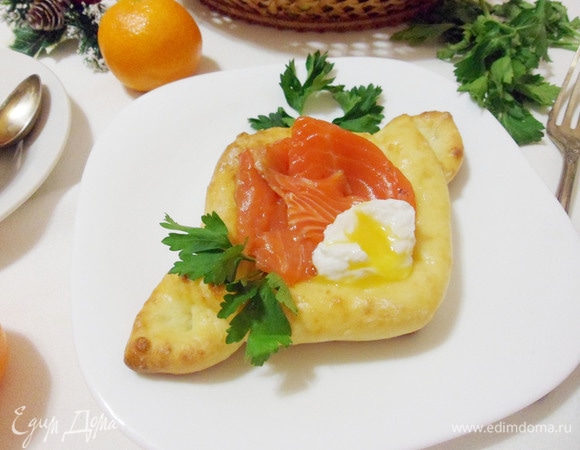 К семге выложить яйцо пашот. Аккуратно надрезать яйцо, украсить сырники зеленью и можно подавать к столу.