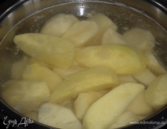 Подготавливаем продукты. Промываем, очищаем и нарезаем картофель. Закладываем картофель в кастрюлю, добавляем воду. Кастрюлю ставим на плиту. Варим картофель до готовности. За 2–3 минуты до окончания варки добавляем 1 ч. л. соли.