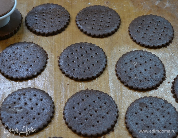 Тесто достать из холодильника, раскатать в пласт между двумя листами пергамента. Затем резаком вырезать печенье. Излишки теста убрать. Выпекать печенье в духовке при 180°C 10 минут.