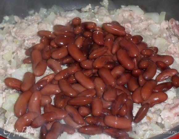 В сковороду к мясному фаршу и овощам добавляем фасоль. Перемешиваем.