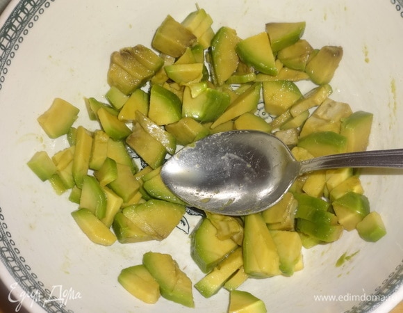 Выложить нарезанное авокадо в чашку, полить лимонным соком, перемешать.