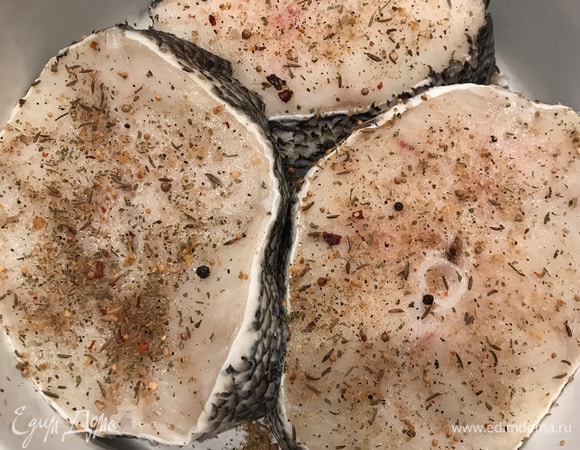 Духовку разогреваем до 200°C. Треску моем, промокаем бумажным полотенцем. Хорошо натираем солью и перцем. Кабачок, картофель, лук, помидор нарезаем тонкими кольцами. Лимон нарезаем дольками. Перец чили разрезаем пополам. Зубчики чеснока также пополам.