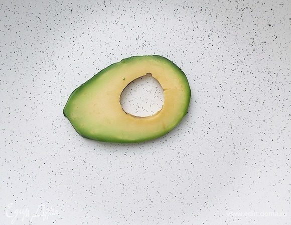 Приступить к сборке салата. На тарелку для подачи выложить первый слайс авокадо.