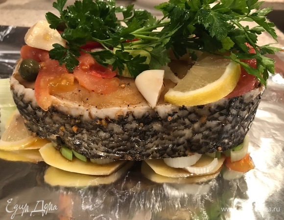 Возьмите два листа фольги. На каждый лист выложите по стейки. На фольге делаем подложку из картофеля, лука, лимона, кабачка. Рыбу кладем на нее. Накрываем сверху: помидоры, кабачок, лимон, чеснок, каперсы, петрушка, перец чили.