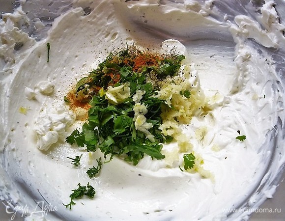 В глубокой чашке смешиваем сливочный сыр со сметаной, взбиваем миксером, добавляем измельченные зелень и чеснок, всыпаем специи, аккуратно перемешиваем. Часть крема нужно отложить для украшения, в него можно специи не добавлять.