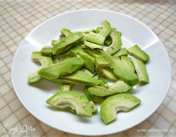 Авокадо и рыбу очищаем и нарезаем тонкими пластинками. Авокадо нужно сбрызнуть лимонным соком. Несколько ломтиков рыбы оставляем для украшения.