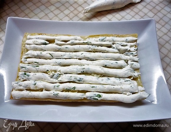 Собираем слоеный торт. Выкладываем первый корж на блюдо и смазываем слоем сливочного крема.