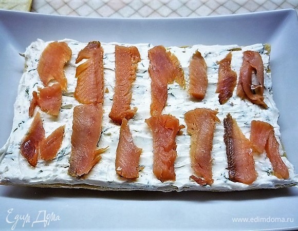 Поверх крема выкладываем ломтики рыбы.