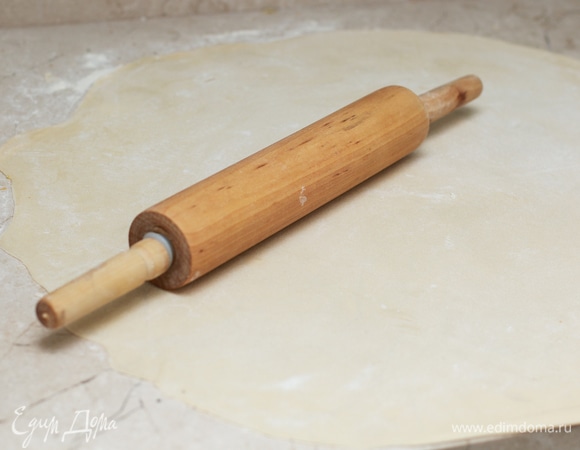 Постепенно посыпая стол мукой, раскатайте один из шаров теста настолько тонко, насколько у вас получится. Со всеми остальными следует поступить так же.