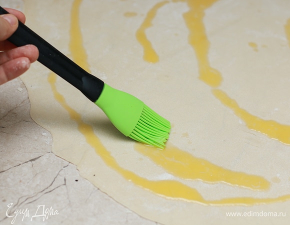 Распределите по раскатанному тесту примерно 5–6 ч. л. сливочного масла, затем размажьте кисточкой или руками.