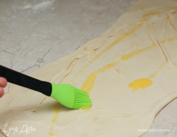 Два противоположных края теста сложите внахлест к середине. Снова смажьте маслом.