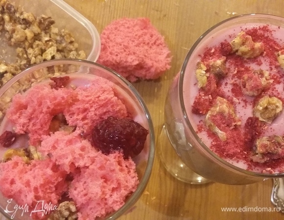 После стабилизации десерта в холодильнике можно приступать к сборке. Для этого потребуется шоколадный декор, меренги, сублимированная малина и малиновое кули. Для хрустящей текстуры положить на слои мусса карамелизированные грецкие орехи или измельченные в ступке козинаки из фундука.