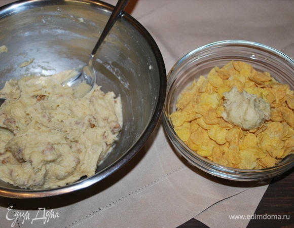 Формируем ложкой шарики и обваливаем их хорошо в кукурузных хлопьях.