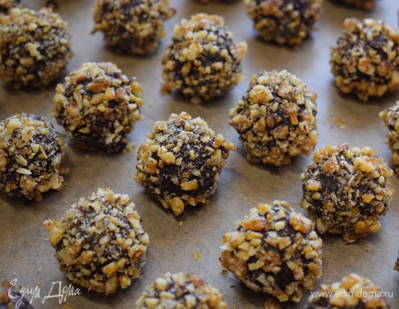 Обмакнуть шарики из ганаша сначала в растопленном шоколаде, а затем обвалять в карамельно-ореховой крошке. Дать конфетам застыть и можно подавать к столу.