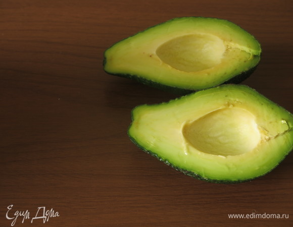 Авокадо разрезаем пополам и вынимаем косточки.
