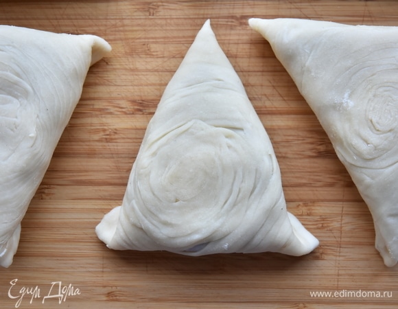 На тесто положить начинку из фарша и закрепить края теста, формируя треугольную самсу. Сверху изделия смазать желтком и посыпать черным кунжутным семенем. Выпекать в духовке, разогретой до 200°C, минут 40.