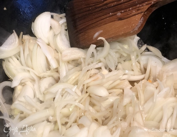 Когда жир полностью вытопится, достать шкварки из казана. Выложить предварительно нарезанный полукольцами лук.