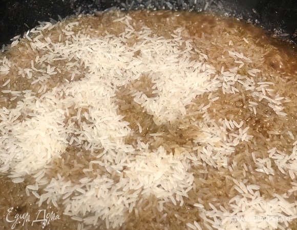 Через 30–40 минут достаньте чеснок и перец. Засыпьте рис. Не перемешивайте!
