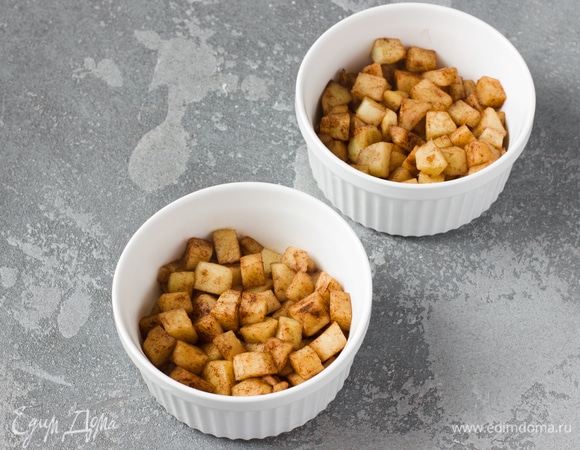 Добавить к яблокам корицу и аккуратно перемешать, равномерно распределяя ее по яблокам. Распределить яблоки по дну форм для запекания (в рецепте использовались формы диаметром 10 см).