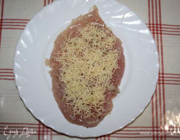 Сыр натереть на мелкой терке. Распределить на каждом кусочке филе.