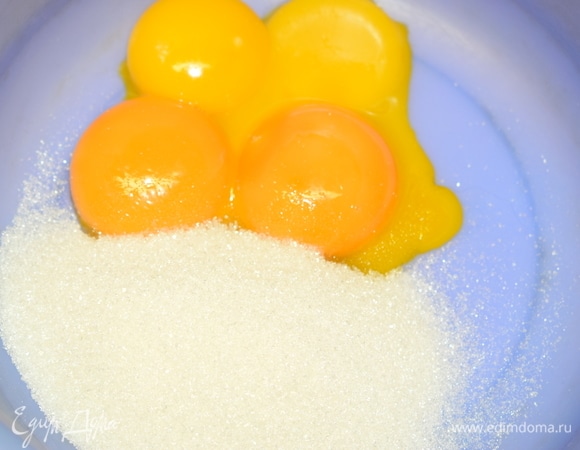 К желткам добавляем оставшийся сахар и взбиваем в пышную пену.