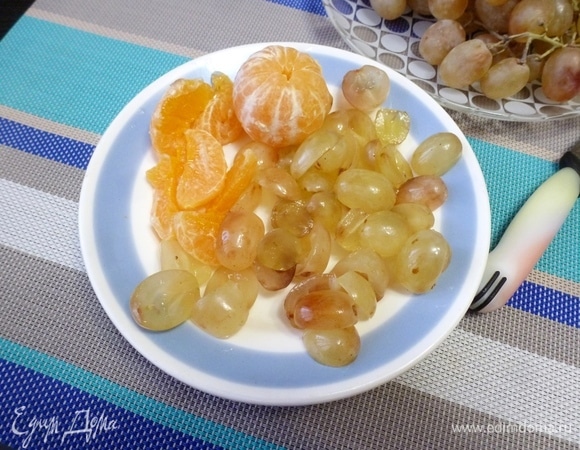 Виноград разрезать и удалить косточки. Мандарин разобрать на дольки.