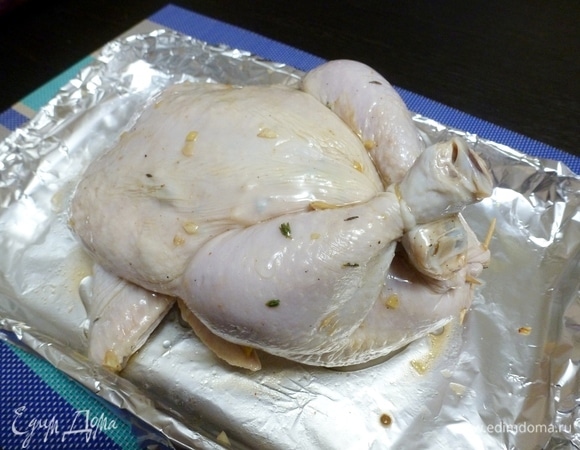 Брюшко сколоть зубочистками, ножки связать, крылышки подогнуть под спинку. Запекать курицу при температуре 170°C около часа, затем увеличить температуру до 200°C и запекать курицу еще минут 20. Если верх будет подгорать, накройте курицу куском фольги. В конце дать курице подрумяниться.