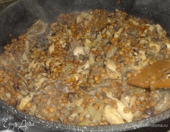 Добавить чечевицу в сковороду с грибами и луком, перемешать, продолжать жарить вместе еще 2–3 минуты.