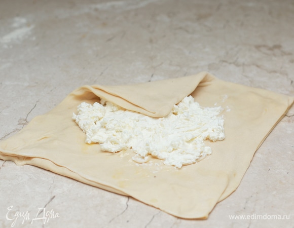 На середину квадрата положите четверть подготовленной начинки, затем по очереди начинайте сгибать края к середине, как у конверта.