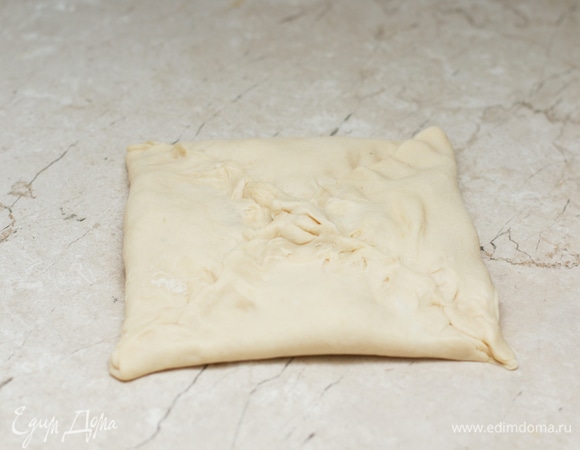 Защипните края и приплюсните хачапури, чтобы он был плоский. С оставшимися тремя шарами теста поступите аналогичным образом.