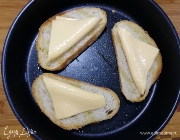 На горячий хлеб кладем по пластинке плавленого сыра.