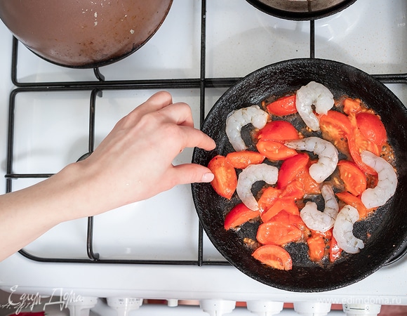 В помидоры высыпаем креветки. Припускаем минуты три.