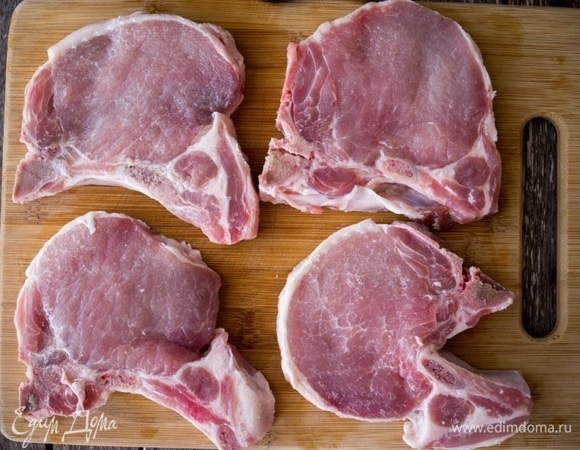 Извлеките из маринада свиные отбивные и слегка отбейте с двух сторон молотком.