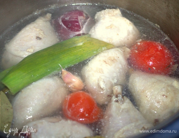 Варим бульон из любой части курицы. У меня набор ножек. Первую воду слить. Добавила пару помидорок, лук-порей, половину репчатой луковицы, чеснок в кожуре, лавровый лист. Можно еще корень сельдерея.