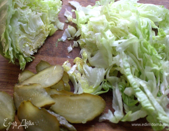 Нарезать салат айсберг и огурцы.
