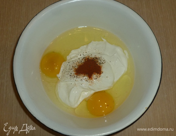 В миску разбить яйца, добавить сметану, соль, перец и паприку. Размешать венчиком до однородности.