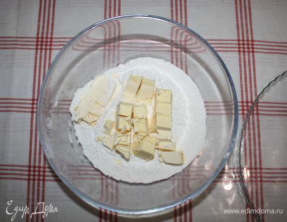 Приготовим основу. В миску просеять муку, выложить нарезанное кубиками сливочное масло.
