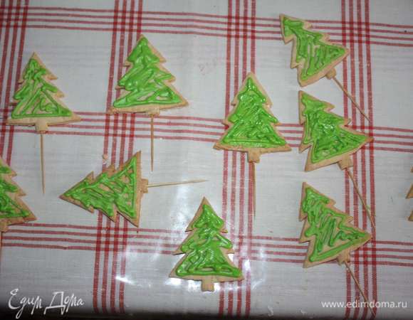 Готовые елочки и звездочки украсить сахарной глазурью (приготовить согласно инструкции на упаковке), глазурь окрасить в желаемый цвет.