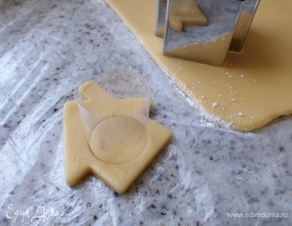 С помощью формочки для теста вырежьте домики. Круглой формочкой вырежьте круг в центре домика.