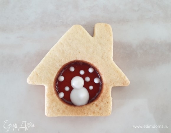 Выдавите из кондитерского мешка на карамель два круга в виде снеговика. Рядом выдавите несколько точек, которые будут снежинками.