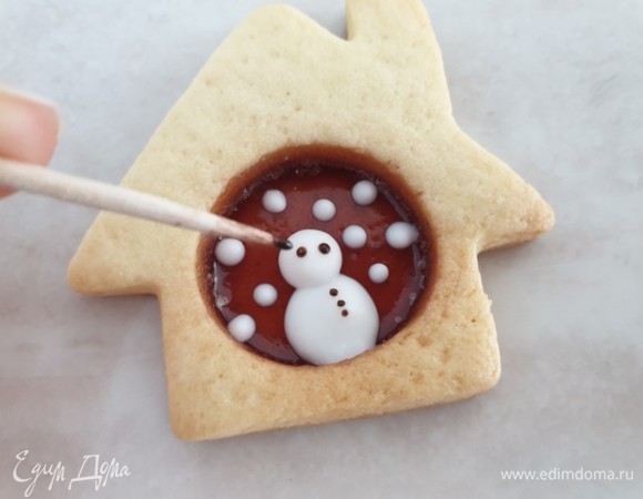 Растопите шоколад в микроволновой печи. Когда глазурь подсохнет, обмакните зубочистку в шоколад и нарисуйте снеговику глазки и пуговицы на теле. Можно также нарисовать улыбку.