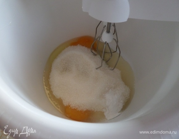 Подготавливаем продукты. С лимона снимаем цедру. В чашку разбиваем яйцо. Добавляем сахар. Взбиваем с помощью миксера в пышную массу. Добавляем растопленное сливочное масло и лимонную цедру. Взбиваем миксером.