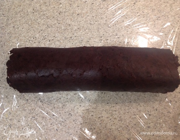 Приподнимаю край пленки. Аккуратно плотно скатываю выпечку с кремом в рулет. Ставлю в холодильник на 10 минут.