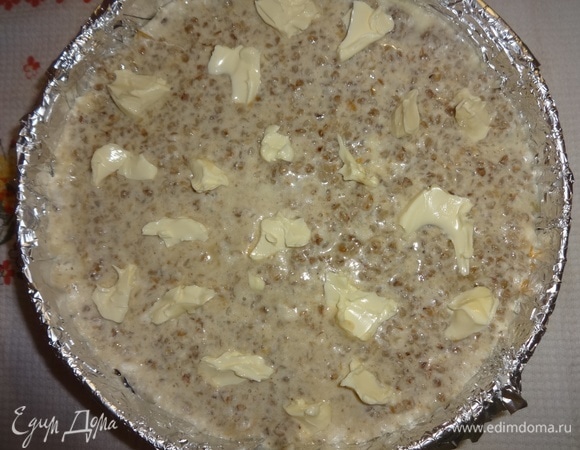 На поверхности гречневого слоя разложить кусочки сливочного масла.