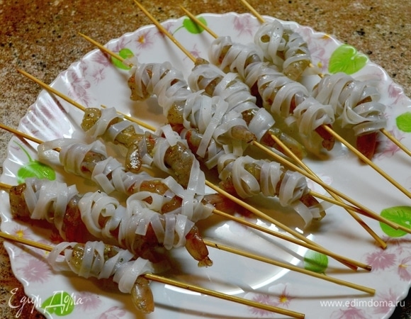 Наколоть креветки на шпажки. Отварить рисовую лапшу и «надеть» ее на креветки)